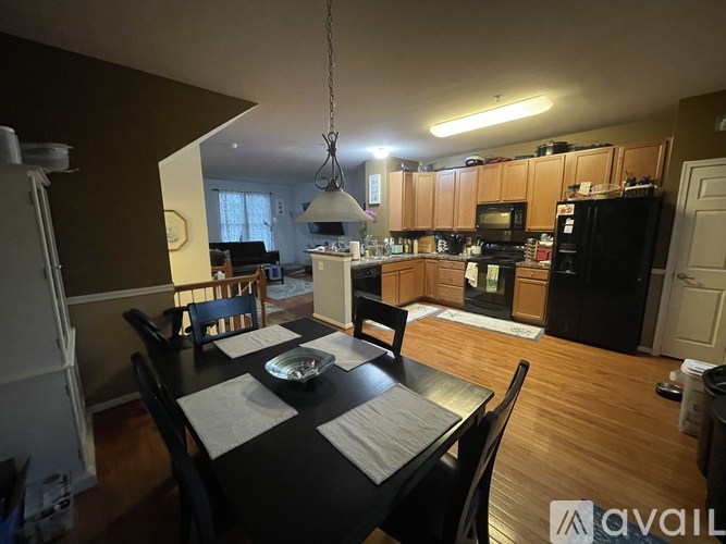 A kitchen with a table set for two and a dining area.