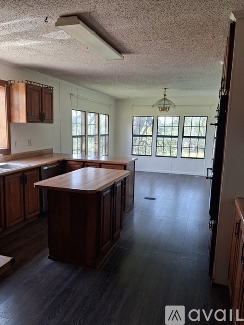 A kitchen with wooden cabinets and a large island.