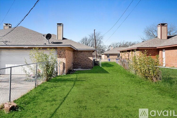 A backyard with a lawn and a fence.