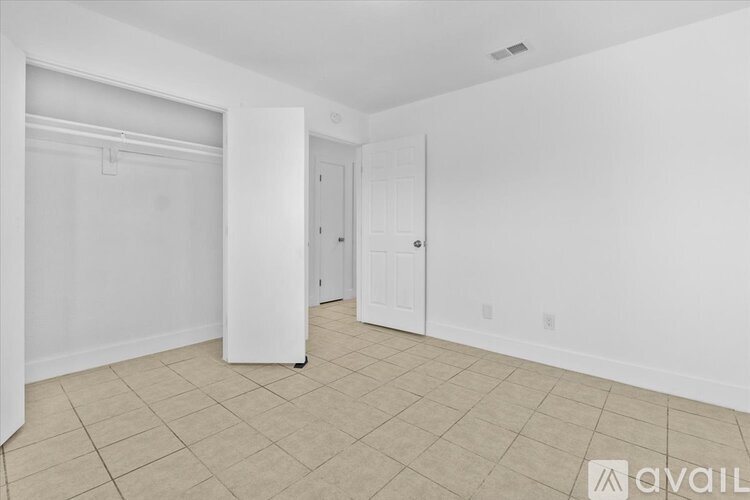 A spacious room with a door and a closet.