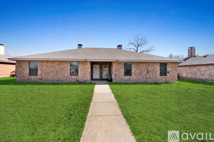 A house with a brick exterior and a large front yard.