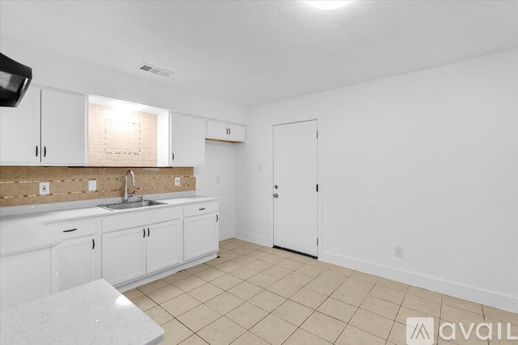 A kitchen with white cabinets and a countertop.