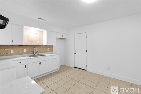 A kitchen with white cabinets and a countertop.