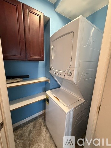A white dishwasher is in a kitchen with blue walls.