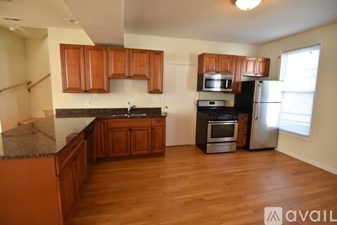 A kitchen with wooden cabinets and a black countertop.