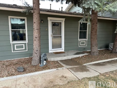 A house with a green siding and a white door is shown.