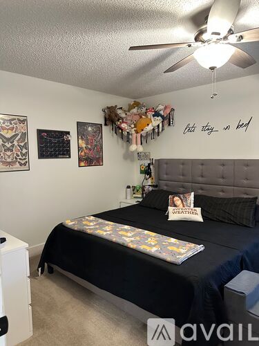 A bedroom with two beds, one with a pillow that says "WEATHER".
