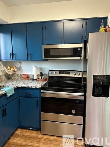 A kitchen with blue cabinets and a white refrigerator.