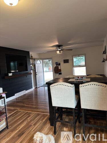 A dining room with a wooden table and chairs.