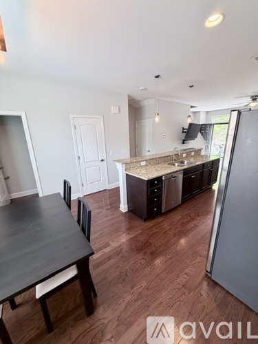 A kitchen with a table and chairs in the foreground and a refrigerator in the background.
