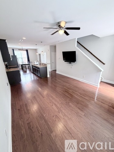 A spacious living room with a staircase leading to the upper floor.