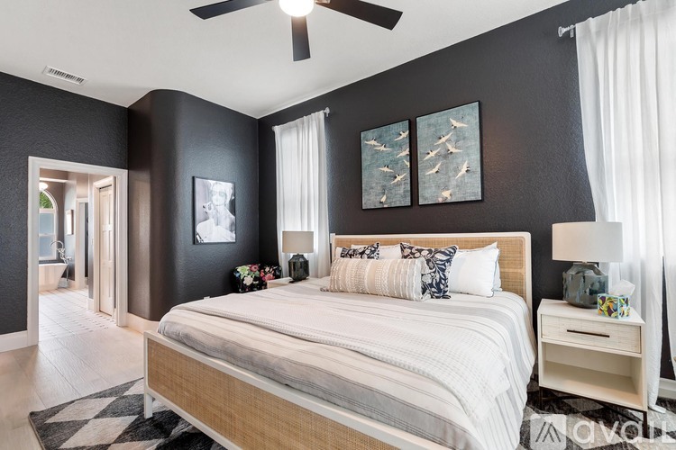 A bedroom with a large bed and a ceiling fan.