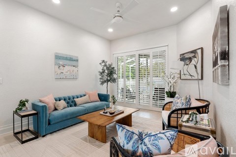 A living room with a blue couch and a wooden coffee table.