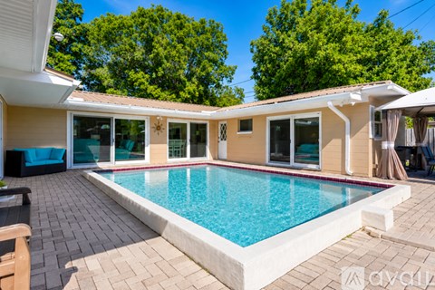 A pool in a backyard with a house in the background.