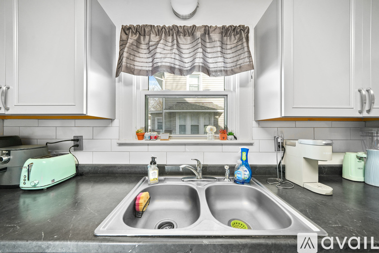 A kitchen with a sink and a toaster on the counter.