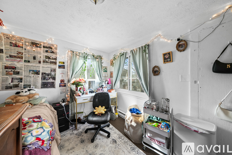 A room with a desk, chair, and a wall covered in newspaper clippings.
