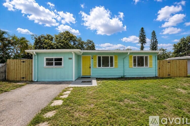 A blue and yellow house with a wooden fence in front.