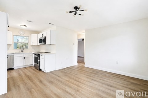 A kitchen with white cabinets and a wooden floor.