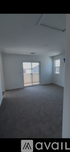 A spacious room with a large window and a door leading to a balcony.