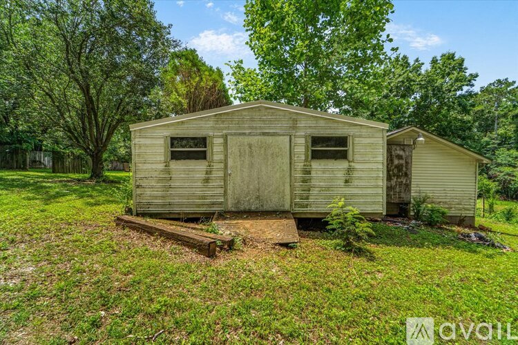 A dilapidated house sits in a grassy field.