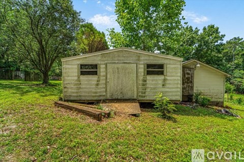 A dilapidated house sits in a grassy field.