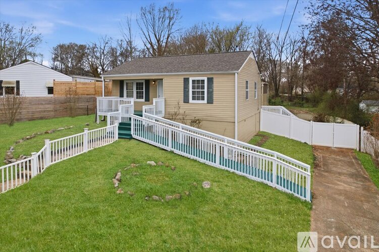 A house with a white fence and a green lawn.