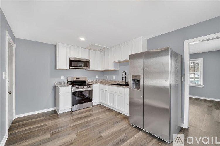 A kitchen with a stainless steel refrigerator, oven, and microwave.