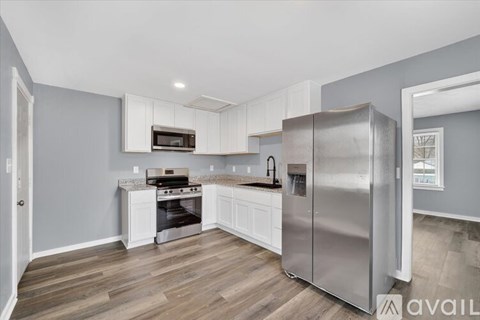A kitchen with a stainless steel refrigerator, oven, and microwave.