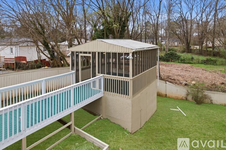 A gazebo with a metal railing is situated in a grassy area.