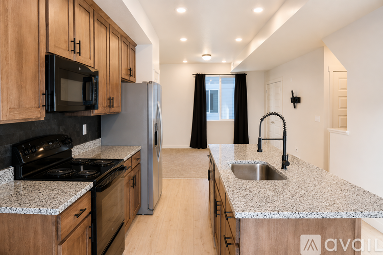 A kitchen with wooden cabinets and granite countertops.