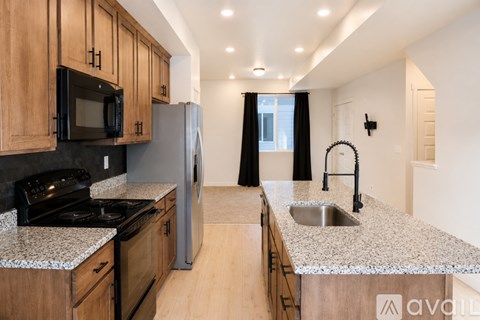 A kitchen with wooden cabinets and granite countertops.