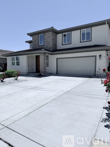 A house with a grey garage door and a brown door.