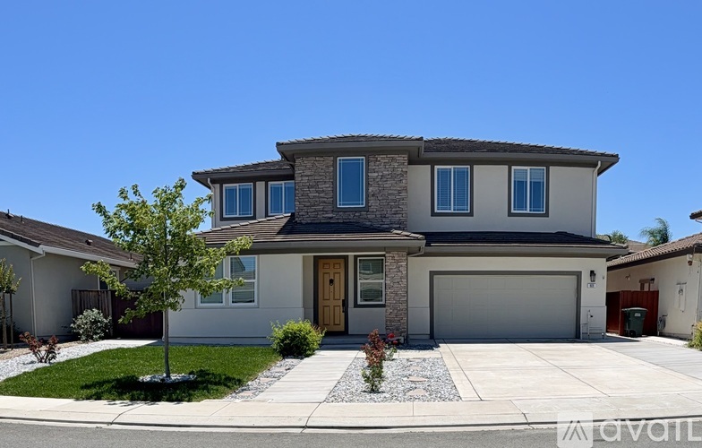 A modern house with a front yard and a garage.