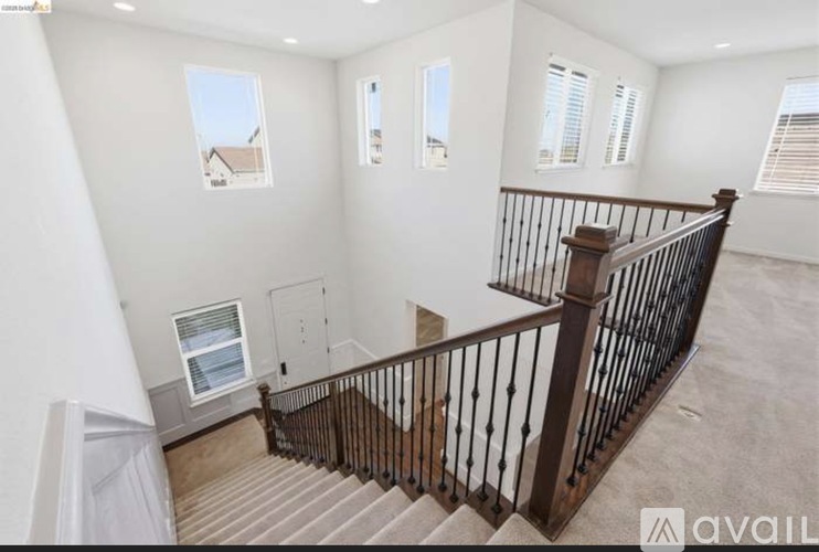 A staircase with a metal railing leads to a second floor.