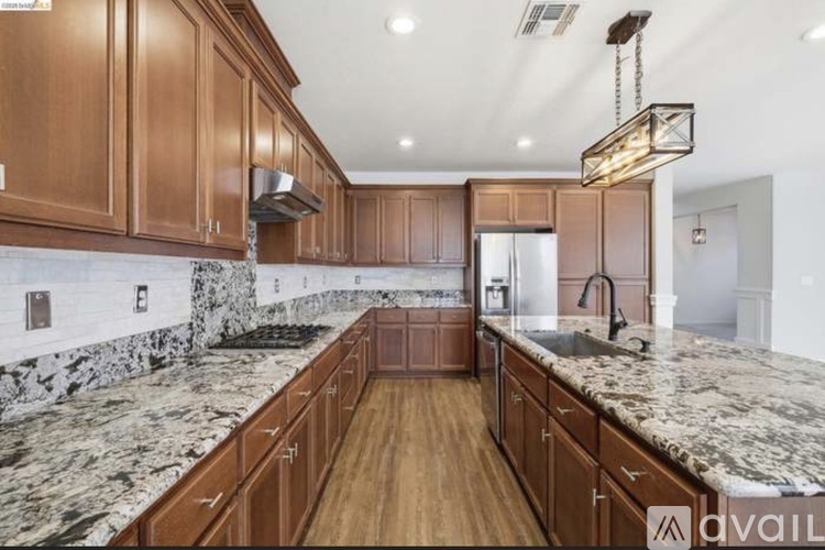 A kitchen with wooden cabinets and marble countertops.