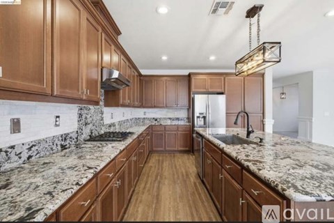 A kitchen with wooden cabinets and marble countertops.