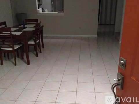 A dining room with a table and chairs.