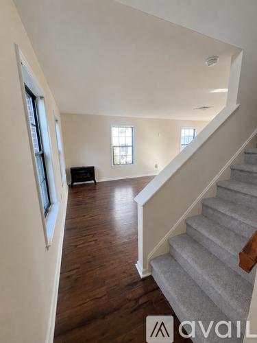 A staircase with a carpeted runner and wooden steps leads up to a second floor.