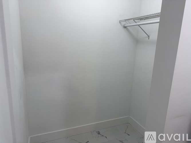 A white wall with a metal shelf on it.