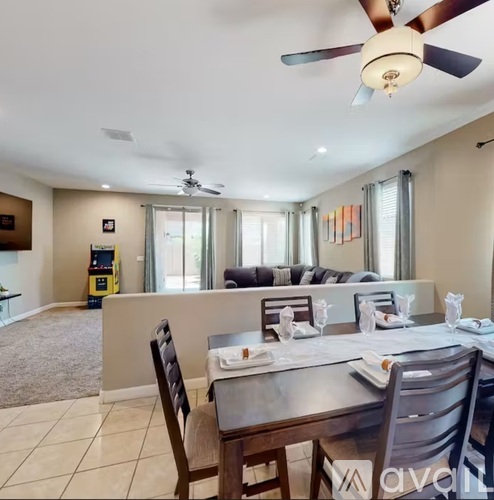A dining room with a table set for two and a ceiling fan.
