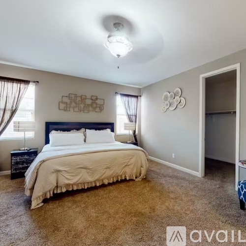 A bedroom with a large bed and a carpeted floor.