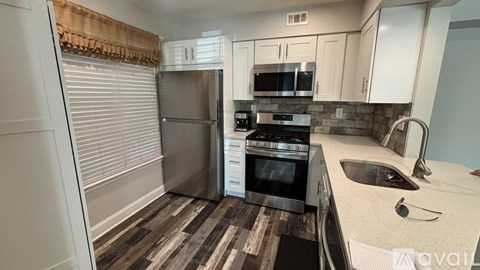 A kitchen with a stove top oven and a refrigerator.