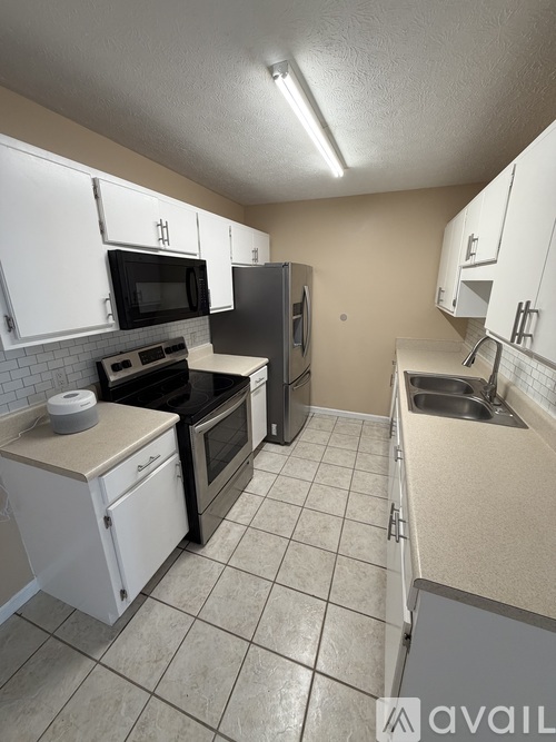 A kitchen with white cabinets and a black stove top oven.
