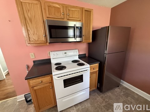 A kitchen with a white stove and black countertop.