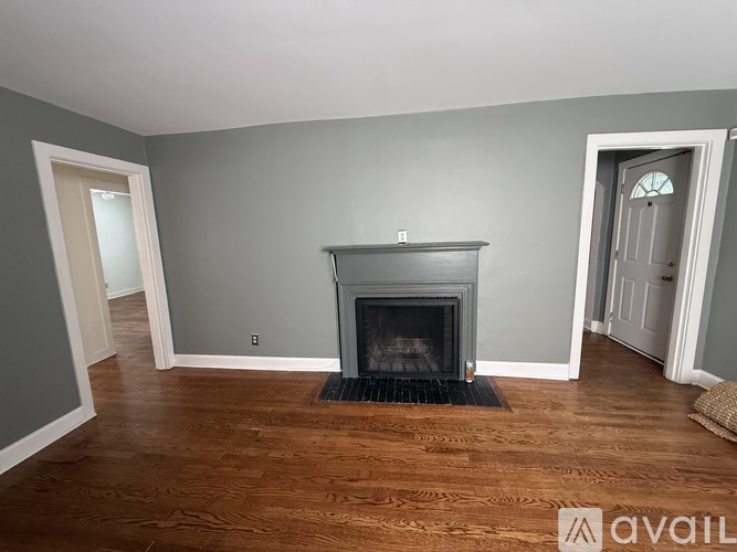 A living room with a fireplace and wood flooring.