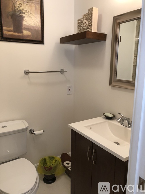 A bathroom with a toilet, sink, and mirror.