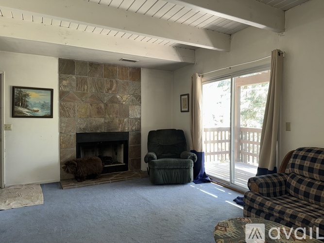 A living room with a fireplace and a painting on the wall.