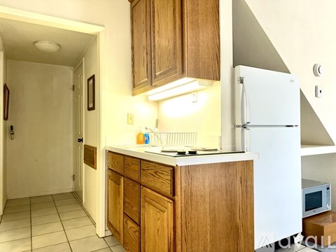 A kitchen with wooden cabinets and a white refrigerator.