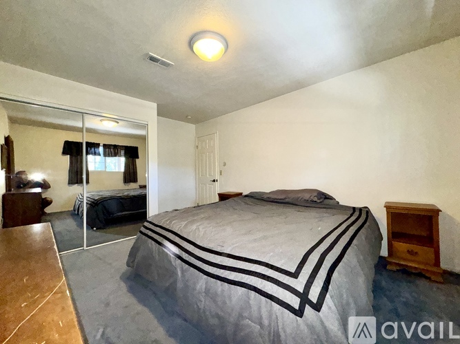 A bedroom with a large bed and a mirror on the wall.