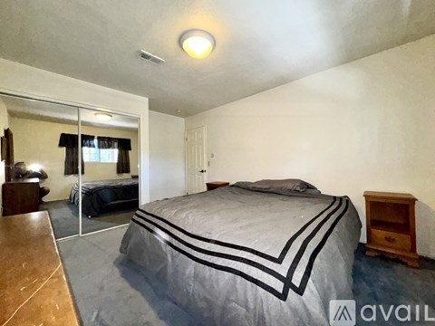 A bedroom with a large bed and a mirror on the wall.